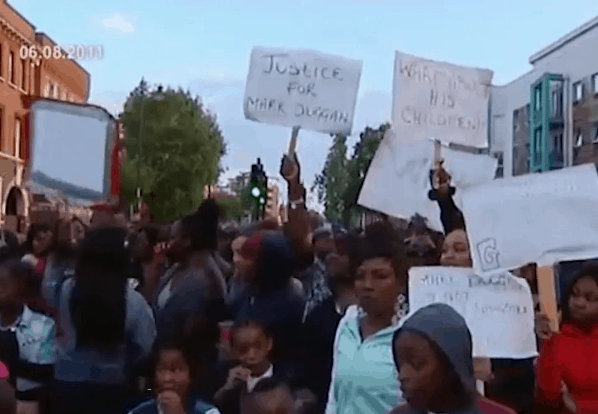 Protesters, Tottenham - On 6 August 2011, protesters hold placards outside Tottenham Police Station. (Euronews) Not for reproduction.
