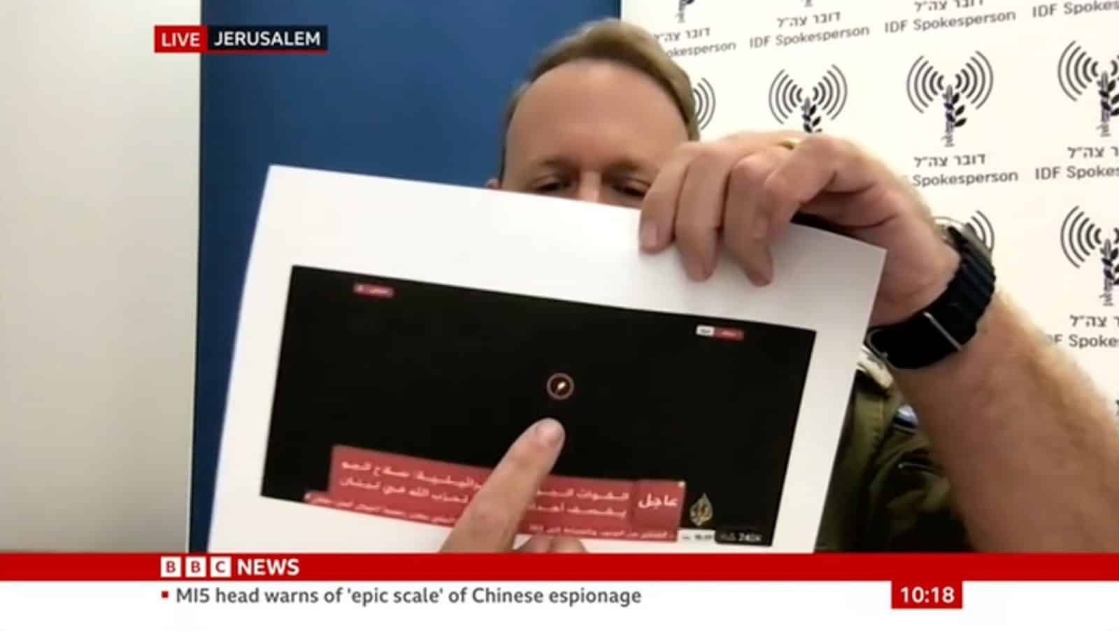  - Lt. Col. Peter Lerner on the BBC holding a printed frame from an Al-Jazeera Livestream, 18 October 2023.