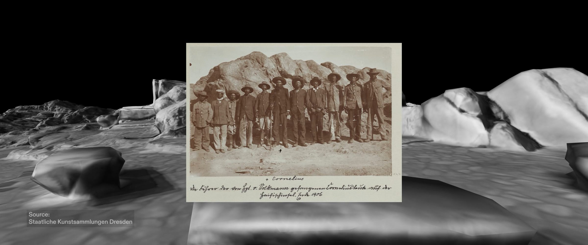 Cornelius Fredericks - A photograph captured in early 1906, featuring Cornelius Fredericks (marked with the cross symbol), Gaob (Nama designation for ‘chief’) of the !Aman Nama clan alongside his fighters, shortly after their capture and arrival to the concentration camp. Image source: Staatliche Kunstsammlungen Dresden (Forensic Architecture/Forensis, 2024)