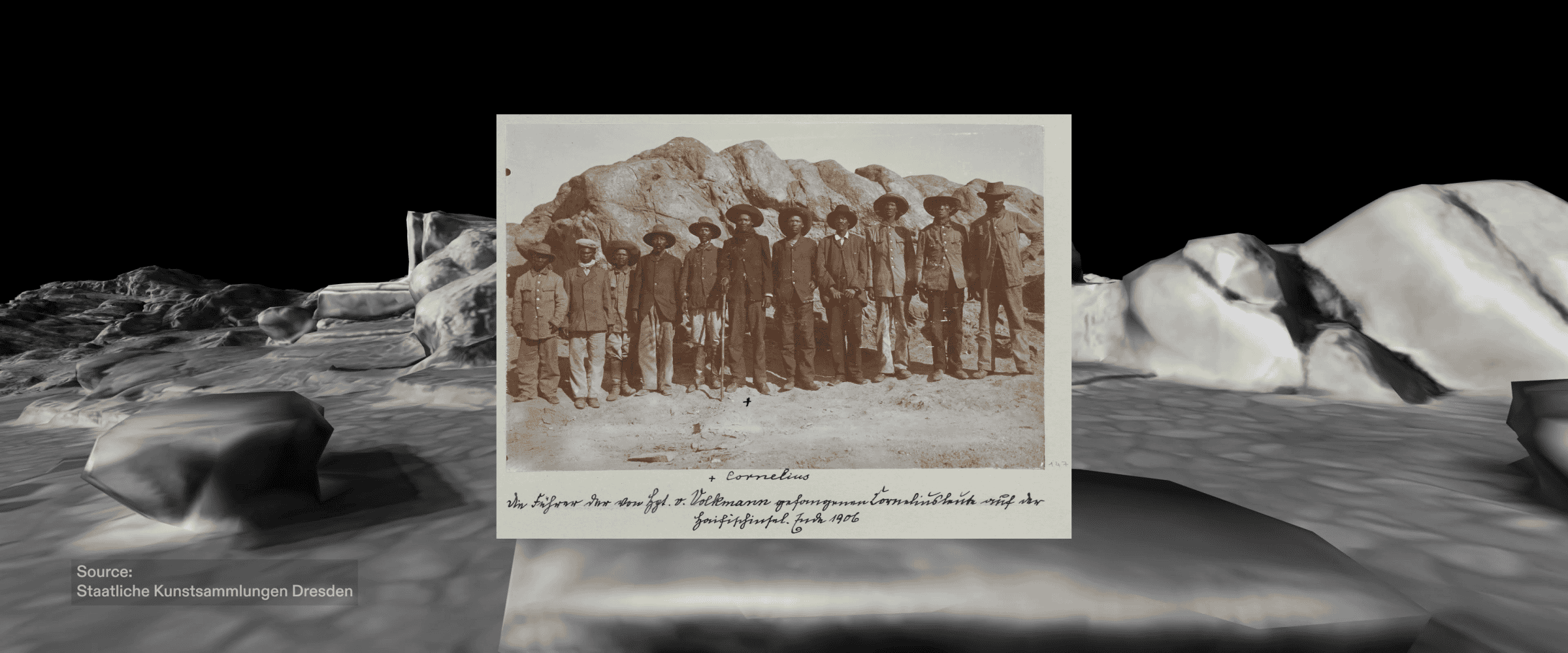 Cornelius Fredericks - A photograph captured in early 1906, featuring Cornelius Fredericks (marked with the cross symbol), Gaob (Nama designation for ‘chief’) of the !Aman Nama clan alongside his fighters, shortly after their capture and arrival to the concentration camp. Image source: Staatliche Kunstsammlungen Dresden (Forensic Architecture/Forensis, 2024)